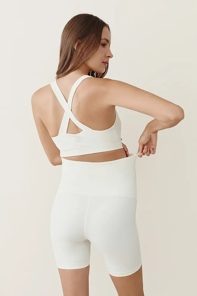 Cream maternity biker shorts designed to accommodate a growing bump during pregnancy